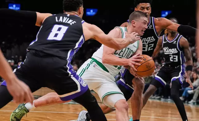 Boston Celtics guard Payton Pritchard, center, drives through the Sacramento Kings' defense during the first half of an NBA basketball game, Friday, Jan. 30, 2026, in Boston. (AP Photo/Charles Krupa)