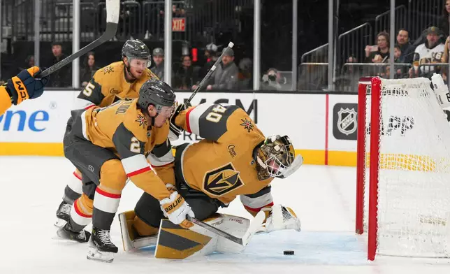 Vegas Golden Knights goaltender Akira Schmid (40) stops a shot from the Nashville Predators during the first period of an NHL hockey game, Wednesday, Dec. 31, 2025, in Las Vegas. (AP Photo/Candice Ward)