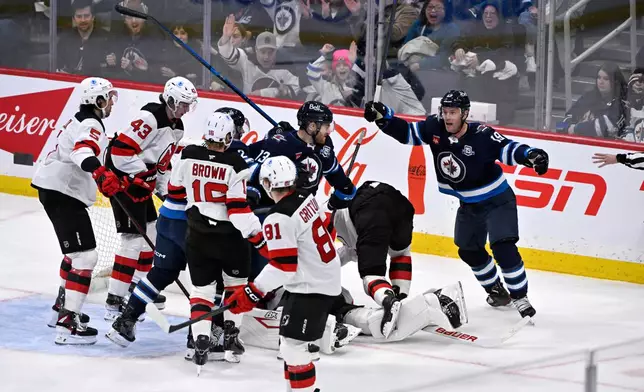 Winnipeg Jets' Gabriel Vilardi (13) celebrates after his goal against the New Jersey Devils with Jonathan Toews (19) during second-period NHL hockey game action in Winnipeg, Manitoba, Sunday, Jan. 11, 2026. (Fred Greenslade/The Canadian Press via AP)