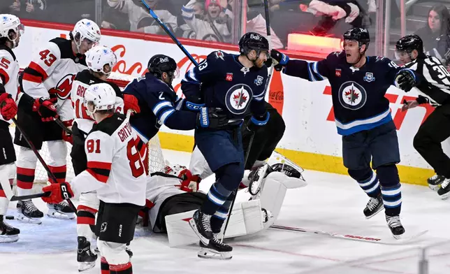 Winnipeg Jets' Gabriel Vilardi (13) celebrates after his goal against the New Jersey Devils with Jonathan Toews (19) and Dylan DeMelo (2) during second-period NHL hockey game action in Winnipeg, Manitoba, Sunday, Jan. 11, 2026. (Fred Greenslade/The Canadian Press via AP)