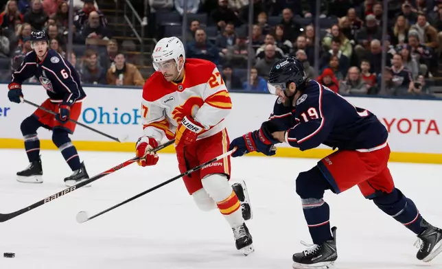 Calgary Flames' Matt Coronato, left, tries to skate past Columbus Blue Jackets' Adam Fantilli during the first period of an NHL hockey game, Tuesday, Jan. 13, 2026, in Columbus, Ohio. (AP Photo/Jay LaPrete)