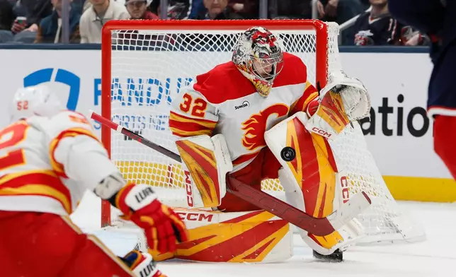 Calgary Flames' Dustin Wolf makes a save against the Columbus Blue Jackets during the first period of an NHL hockey game, Tuesday, Jan. 13, 2026, in Columbus, Ohio. (AP Photo/Jay LaPrete)