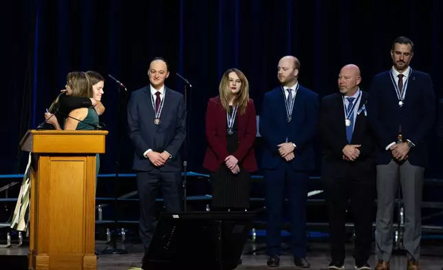 First responders accept medals at an event honoring the 67 lives lost in the 2025 midair collision near DCA airport, Wednesday, Jan. 28, 2026, in Washington. (AP Photo/Allison Robbert)