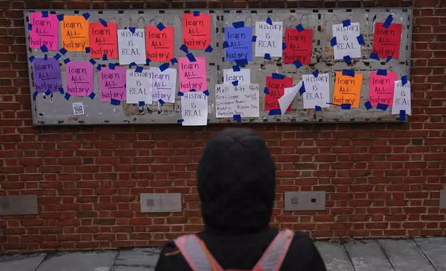 A person views posted signs on the locations of the now removed explanatory panels that were part of an exhibit on slavery at President's House Site in Philadelphia, Friday, Jan. 23, 2026. (AP Photo/Matt Rourke)