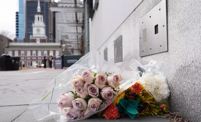 Flowers lay by the locations of a now removed explanatory panels that were part of an exhibit on slavery at President's House Site in Philadelphia, Friday, Jan. 23, 2026. (AP Photo/Matt Rourke)
