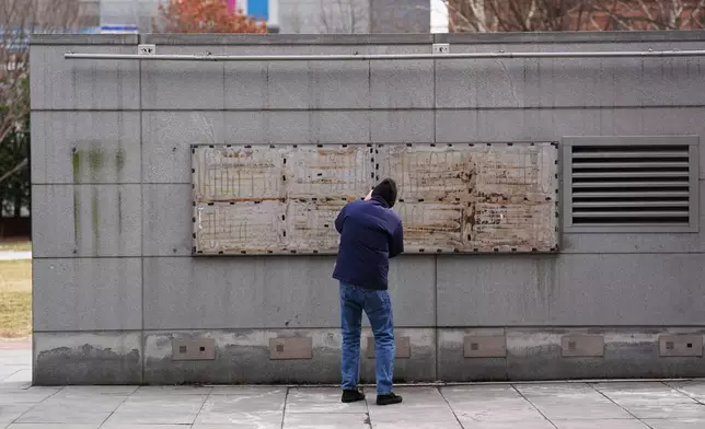 A person films the location of a now removed explanatory panels that were part of an exhibit on slavery at President's House Site in Philadelphia, Friday, Jan. 23, 2026. (AP Photo/Matt Rourke)