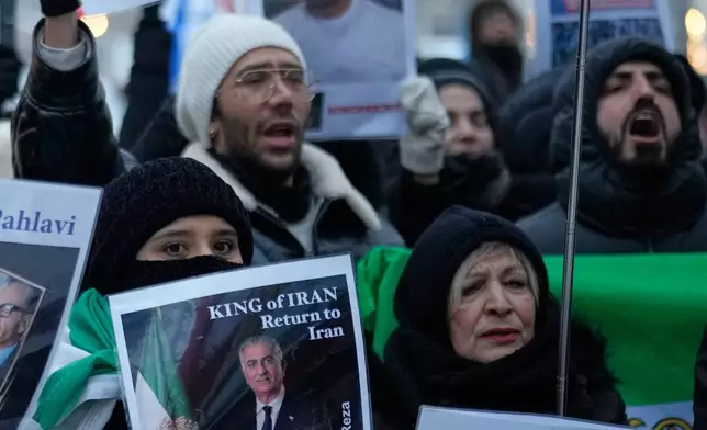 FILE - Protesters hold pictures of Reza Pahlavi, Crown Prince of Iran, at a demonstration against the Iranian government, in Berlin, Germany, Jan. 9, 2026. (AP Photo/Ebrahim Noroozi, File)