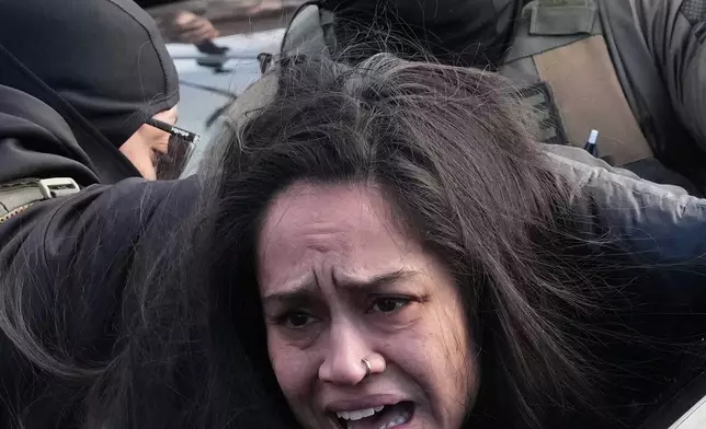 FILE - A person is detained by federal agents in Minneapolis, Jan. 13, 2026, near the scene where Renee Good was fatally shot by an ICE officer last week. (AP Photo/Adam Gray, File)