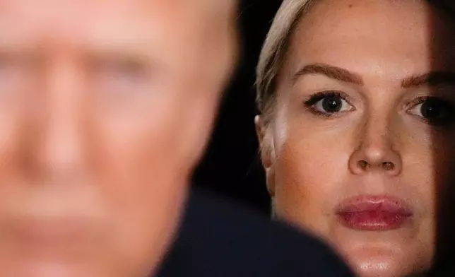 FILE - White House Press Secretary Karoline Leavitt watches as President Donald Trump speaks to reporters while in flight on Air Force One to Joint Base Andrews, Md., Jan. 11, 2026. (AP Photo/Julia Demaree Nikhinson, File)