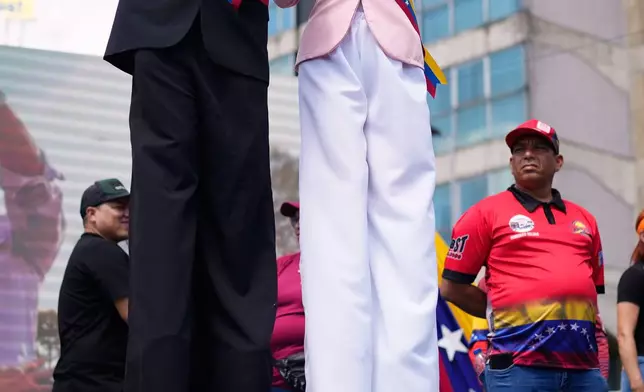 FILE - Performers on stilts dressed as former Venezuelan President Nicolas Maduro and First Lady Cilia Flores wave during a march calling for their release after U.S. forces captured them, in Caracas, Venezuela, Jan. 9, 2026. (AP Photo/Ariana Cubillos, File)