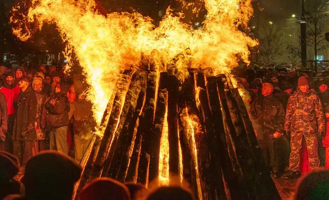 FILE - People watch a bonfire in Independence Square on the eve of the 35th anniversary of the Day of the Defenders of Freedom, in Vilnius, Lithuania, Jan. 12, 2026. (AP Photo/Mindaugas Kulbis, File)