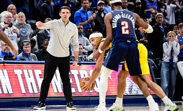 Oklahoma City Thunder head coach Mark Daigneault, front left, gestures to Thunder guard Shai Gilgeous-Alexander (2) during the second half of an NBA basketball game against the Indiana Pacers, Friday, Jan. 23, 2026, in Oklahoma City. (AP Photo/Gerald Leong)