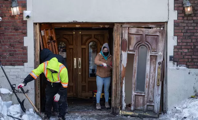 People clean up the scene where a car slammed into the entrance of the Chabad Lubavitch world headquarters, Thursday, Jan. 29, 2026, in New York. (AP Photo/Yuki Iwamura)