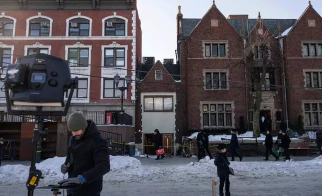 Members of the media work near the scene where a car slammed into the entrance of the Chabad Lubavitch world headquarters, Thursday, Jan. 29, 2026, in New York. (AP Photo/Yuki Iwamura)
