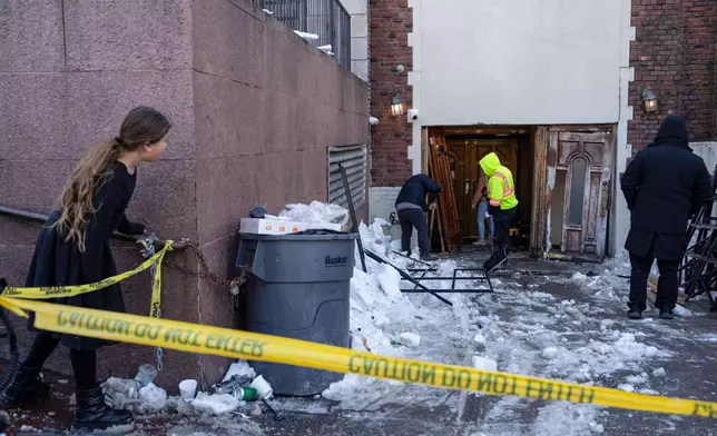 A person watches the scene where a car slammed into the entrance of the Chabad Lubavitch world headquarters, Thursday, Jan. 29, 2026, in New York. (AP Photo/Yuki Iwamura)
