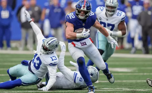New York Giants tight end Daniel Bellinger (82) breaks tackles on his way to a touchdown against the Dallas Cowboys during the second quarter of an NFL football game, Sunday, Jan. 4, 2026, in East Rutherford, N.J. (AP Photo/Frank Franklin II)