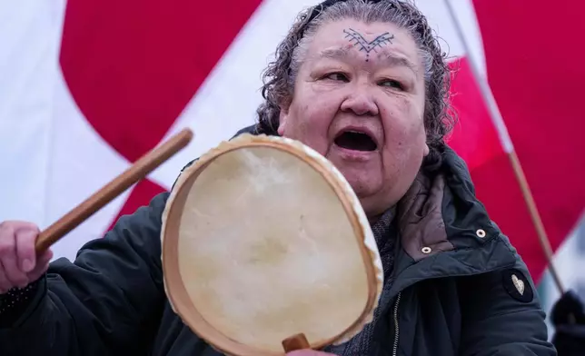 An Inuit woman sings a national song during a protest against Trump's policy towards Greenland in front of the US consulate in Nuuk, Greenland, Saturday, Jan. 17, 2026. (AP Photo/Evgeniy Maloletka)
