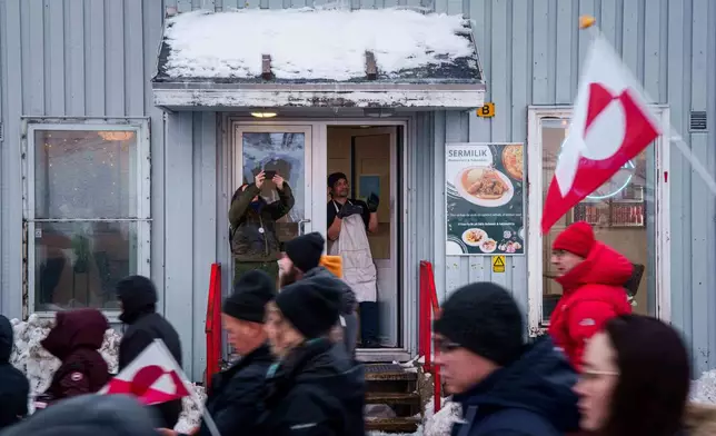 A cafe worker applauds in support of a protest march against Trump's policy towards Greenland in Nuuk, Saturday, Jan. 17, 2026. (AP Photo/Evgeniy Maloletka)