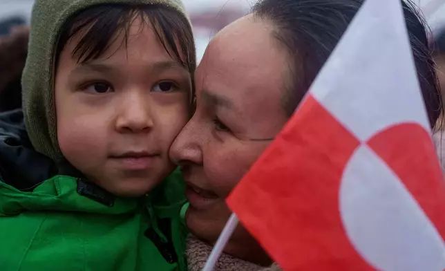An Inuit woman holds her child during a protest against Trump's policy towards Greenland in front of the US consulate in Nuuk, Greenland, Saturday, Jan. 17, 2026. (AP Photo/Evgeniy Maloletka)