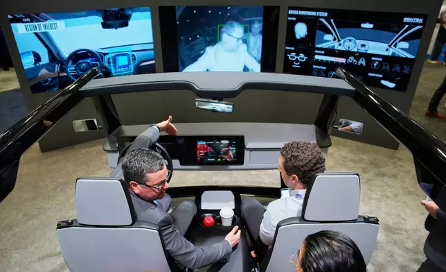 People experience a Gentex Corporation driver and in-camera monitoring system exhibit during the CES tech show Tuesday, Jan. 6, 2026, in Las Vegas. (AP Photo/John Locher)
