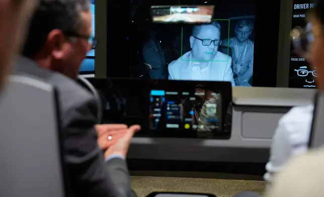 People experience a Gentex Corporation driver and in-camera monitoring system exhibit during the CES tech show Tuesday, Jan. 6, 2026, in Las Vegas. (AP Photo/John Locher)
