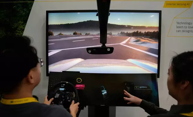 People take part in a simulator for Smart Eye interior sensing AI technology at the Smart Eye booth during the CES tech show Tuesday, Jan. 6, 2026, in Las Vegas. (AP Photo/John Locher)