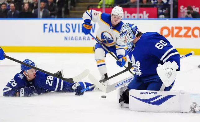 Toronto Maple Leafs goaltender Joseph Woll (60) makes a save as Troy Stecher (28) defends against Zach Benson (6) during third period NHL action in Toronto, Ontario, Tuesday, Jan. 27, 2026. (Frank Gunn/The Canadian Press via AP)