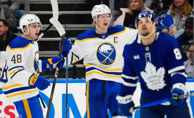 Buffalo Sabres' Rasmus Dahlin, center, celebrates his goal with Tyson Kozak (48) as Toronto Maple Leafs' Nicholas Robertson (89) skates during the second period of an NHL hockey game in Toronto, Tuesday, Jan. 27, 2026. (Frank Gunn/The Canadian Press via AP)