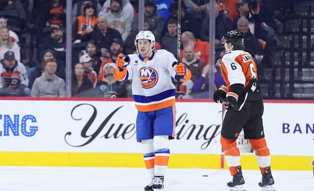 New York Islanders' Mathew Barzal, left, celebrates past Philadelphia Flyers' Travis Sanheim after scoring a goal during the second period of an NHL hockey game Monday, Jan. 26, 2026, in Philadelphia. (AP Photo/Matt Slocum)