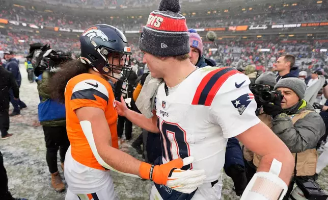Denver Broncos safety Talanoa Hufanga, left, greets New England Patriots quarterback Drake Maye after the AFC Championship NFL football game, Sunday, Jan. 25, 2026, in Denver. (AP Photo/Ashley Landis)