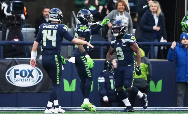Seattle Seahawks running back Kenneth Walker III (9) celebrates his touchdown run with wide receiver Rashid Shaheed (22) and quarterback Sam Darnold (14) during the first half of the NFC Championship NFL football game against the Los Angeles Rams, Sunday, Jan. 25, 2026, in Seattle. (AP Photo/Lindsey Wasson)