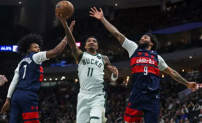 Milwaukee Bucks' Gary Harris drives to the basket between Washington Wizards' Bub Carrington and Justin Champagnie during the first half of an NBA basketball game, Wednesday, Dec. 31, 2025, in Milwaukee. (AP Photo/Kylie Bridenhagen)