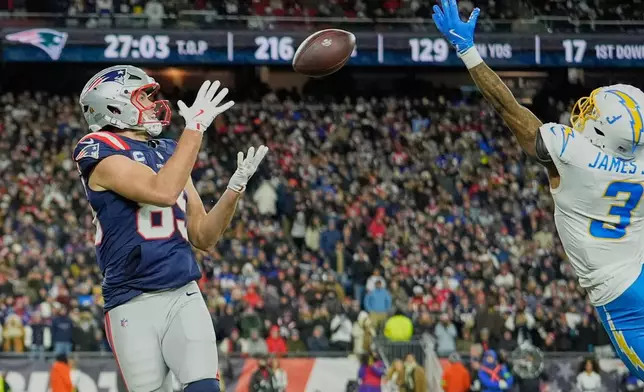 New England Patriots tight end Hunter Henry, left, catches a pass next to Los Angeles Chargers safety Derwin James Jr. (3) and carries it in for a touchdown in the second half of an NFL wild-card playoff football game in Foxborough, Mass., Sunday, Jan. 11, 2026. (AP Photo/Robert F. Bukaty)