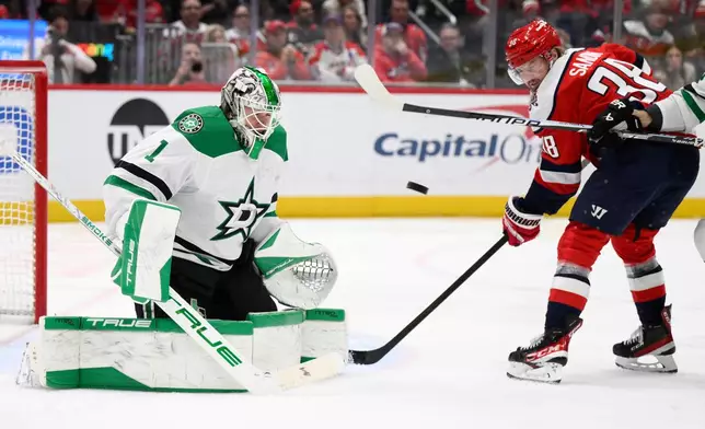 Dallas Stars goaltender Casey Desmith (1) and Washington Capitals defenseman Rasmus Sandin (38) battle for the puck during the first period of an NHL hockey game, Wednesday, Jan. 7, 2026, in Washington. (AP Photo/Nick Wass)