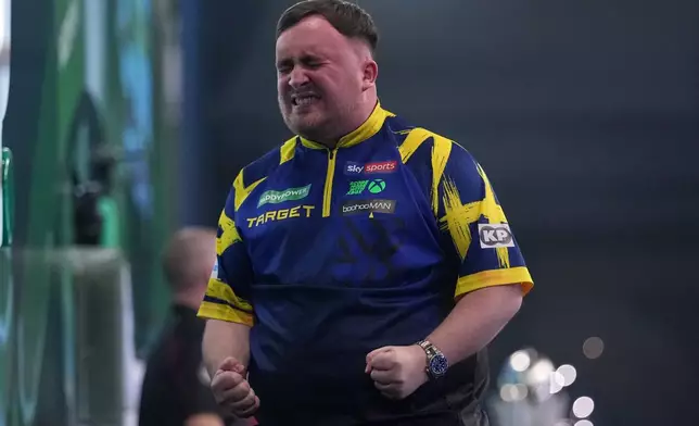 England's Luke Littler reacts after winning the World Darts Championships final match against Gian van Veen of the Netherlands at Alexandra Palace in London, Saturday, Jan. 3, 2026.(AP Photo/Dave Shopland)