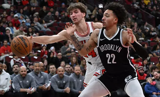 Brooklyn Nets' Jalen Wilson (22) battles Chicago Bulls' Matas Buzelis (14) for a loose ball during the first half of an NBA basketball game Sunday, Jan. 18, 2026, in Chicago. (AP Photo/Paul Beaty)