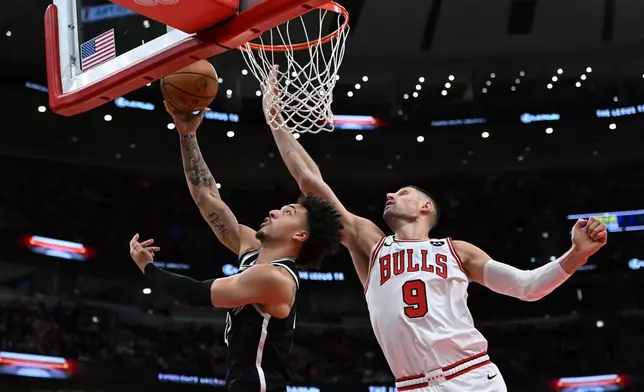 Brooklyn Nets' Jalen Wilson (22) goes up for a shot against Chicago Bulls' Nikola Vucevic (9) during the first half of an NBA basketball game Sunday, Jan. 18, 2026, in Chicago. (AP Photo/Paul Beaty)