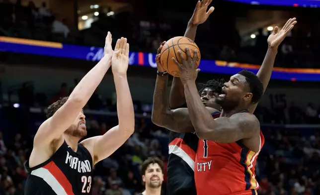 New Orleans Pelicans forward Zion Williamson (1) shoots against Portland Trail Blazers center Donovan Clingan (23) and guard Sidy Cissoko during the first half of an NBA basketball game in New Orleans, Friday, Jan. 2, 2026. (AP Photo/Matthew Hinton)