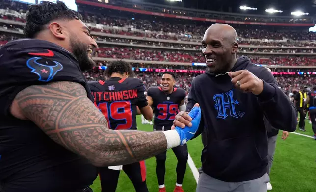 Houston Texans defensive tackle Tommy Togiai, left, celebrates his touchdown against the Indianapolis Colts with head coach Demeco Ryans, right, during the second half of an NFL football game in Houston, Sunday, Jan. 4, 2026. (AP Photo/Ashley Landis)