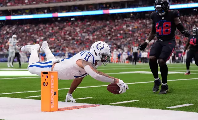 Indianapolis Colts wide receiver Michael Pittman Jr. (11) dives in an attempt to make a first down against the Houston Texans during the second half of an NFL football game in Houston, Sunday, Jan. 4, 2026. (AP Photo/Ashley Landis)