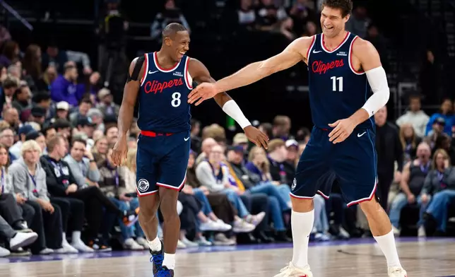 Los Angeles Clippers guard Kris Dunn (8) and center Brook Lopez (11) celebrate a play during the second half of an NBA basketball game against the Utah Jazz, Tuesday, Jan. 27, 2026, in Salt Lake City. (AP Photo/Anna Fuder)
