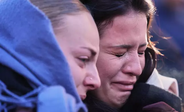 People mourn during a memorial procession in Crans-Montana, Swiss Alps, Switzerland, Sunday, Jan. 4, 2026, after a devastating fire in Le Constellation bar left dead and injured during the New Year's celebrations. (AP Photo/ Antonio Calanni)