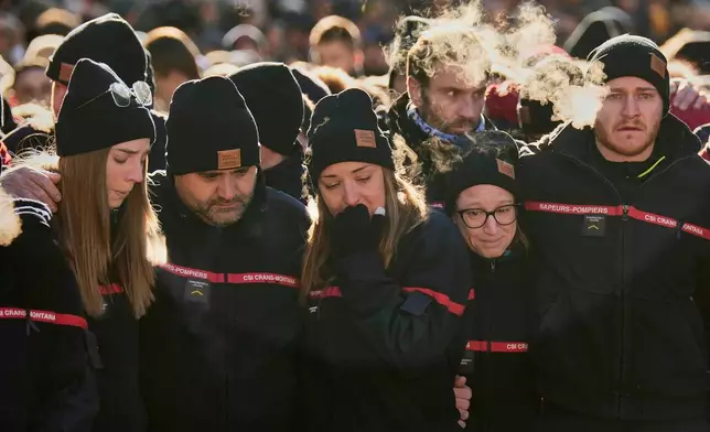 Firefighters cry, standing outside the Chapelle St-Christophe, during a memorial mass in Crans-Montana, Swiss Alps, Switzerland, Sunday, Jan. 4, 2026, after a devastating fire in Le Constellation bar left dead and injured during the New Year's celebrations. (AP Photo/Baz Ratner)