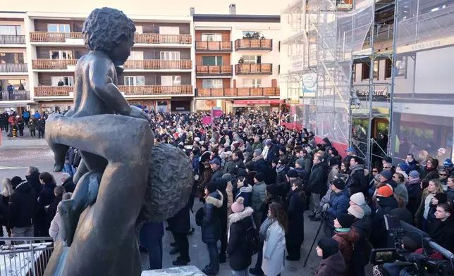 People stand outside the Chapelle St-Christophe during a memorial mass in Crans-Montana, Swiss Alps, Switzerland, Sunday, Jan. 4, 2026, after a devastating fire in Le Constellation bar left dead and injured during the New Year's celebrations. (AP Photo/ Antonio Calanni)