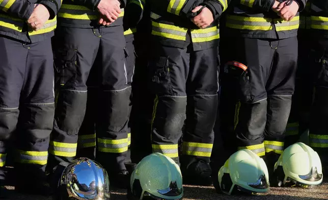 Firefighters stand outside the Chapelle St-Christophe during a memorial mass in Crans-Montana, Swiss Alps, Switzerland, Sunday, Jan. 4, 2026, after a devastating fire in Le Constellation bar left dead and injured during the New Year's celebrations. (AP Photo/ Antonio Calanni)