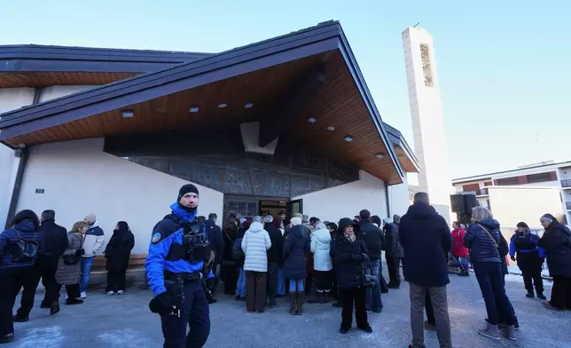 People stand outside the Chapelle St-Christophe during a memorial mass in Crans-Montana, Swiss Alps, Switzerland, Sunday, Jan. 4, 2026, after a devastating fire in Le Constellation bar left dead and injured during the New Year's celebrations. (AP Photo/ Antonio Calanni)