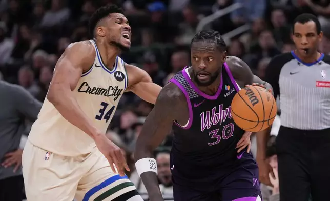 Minnesota Timberwolves' Julius Randle gets past Milwaukee Bucks' Giannis Antetokounmpo during the first half of an NBA basketball game Tuesday, Jan. 13, 2026, in Milwaukee. (AP Photo/Morry Gash)