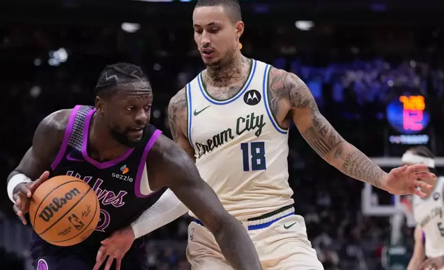 Minnesota Timberwolves' Julius Randle tries to get past Milwaukee Bucks' Kyle Kuzma during the first half of an NBA basketball game Tuesday, Jan. 13, 2026, in Milwaukee. (AP Photo/Morry Gash)