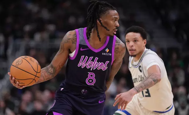 Minnesota Timberwolves' Bones Hyland gets past Milwaukee Bucks' Ryan Rollins during the first half of an NBA basketball game Tuesday, Jan. 13, 2026, in Milwaukee. (AP Photo/Morry Gash)
