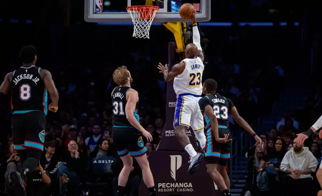 Los Angeles Lakers forward LeBron James (23) goes to the basket against the Memphis Grizzlies during the first half of an NBA basketball game Sunday, Jan. 4, 2026, in Los Angeles. (AP Photo/Ethan Swope)